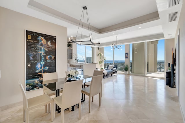 dining space featuring an inviting chandelier, floor to ceiling windows, and a tray ceiling