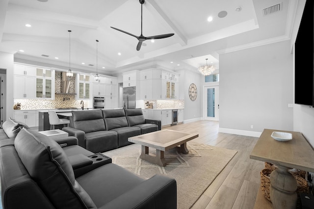 living room featuring lofted ceiling with beams, beverage cooler, ceiling fan, light hardwood / wood-style floors, and crown molding