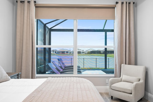 bedroom featuring a water view and wood-type flooring