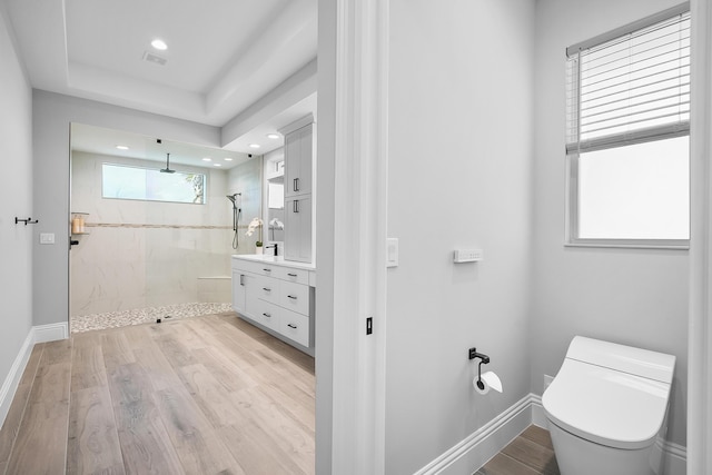 bathroom featuring hardwood / wood-style flooring, vanity, and a tile shower