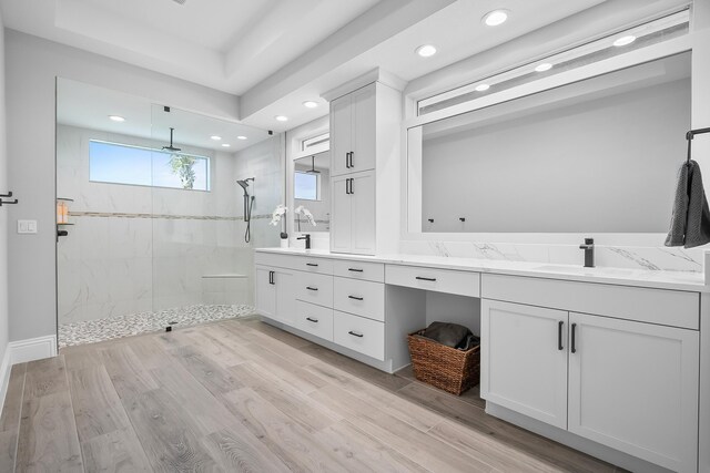 bathroom featuring vanity, hardwood / wood-style floors, and tiled shower