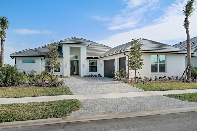 view of front of house featuring a garage and a front lawn