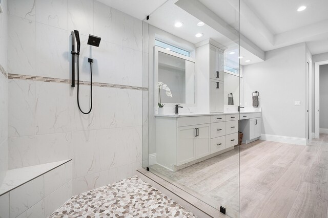 bathroom with vanity, hardwood / wood-style flooring, and tiled shower