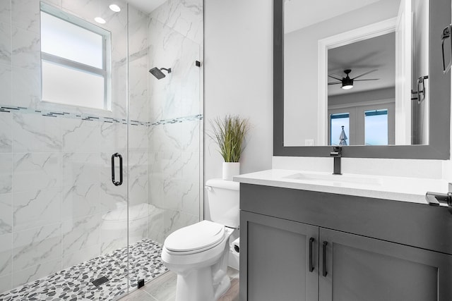 bathroom with vanity, an enclosed shower, toilet, and ceiling fan