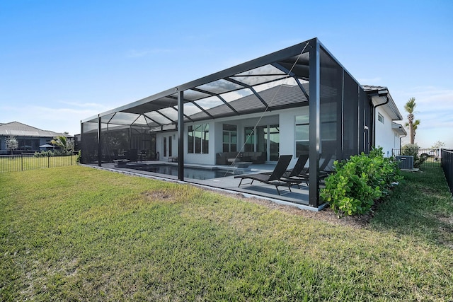 back of house with a fenced in pool, a lawn, a patio, and glass enclosure