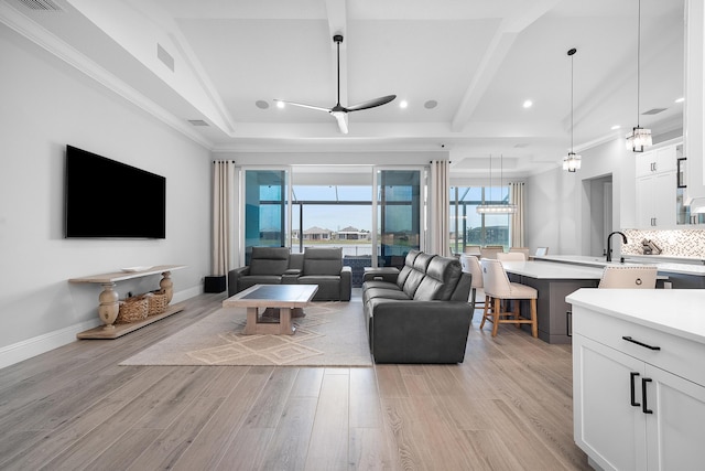 living room featuring vaulted ceiling with beams, light hardwood / wood-style flooring, ornamental molding, and ceiling fan