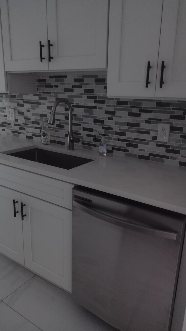 kitchen with tasteful backsplash, white cabinetry, and stainless steel dishwasher