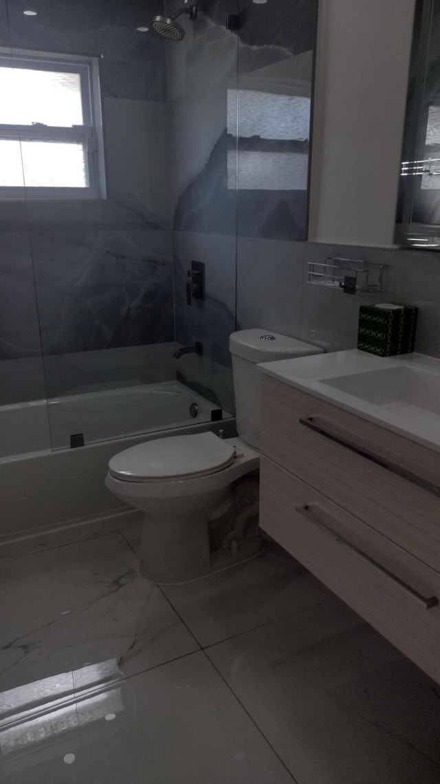 full bathroom with vanity, tiled shower / bath combo, tile walls, and toilet