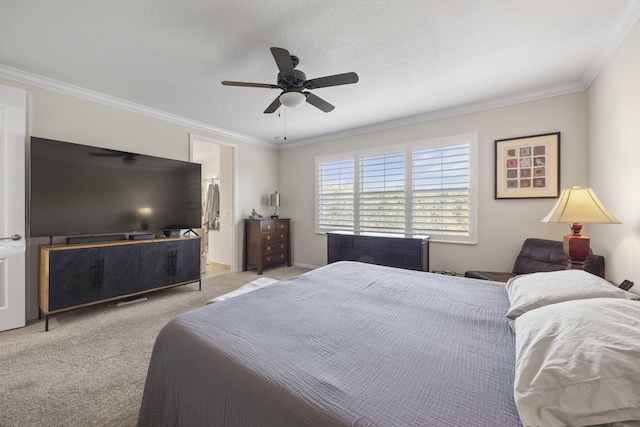 carpeted bedroom featuring ceiling fan, ornamental molding, and a textured ceiling