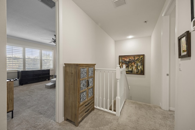 corridor with light colored carpet and crown molding