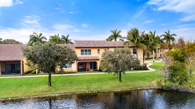 view of front of property featuring a front lawn and a water view