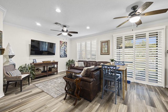 living room with wood-type flooring and ornamental molding