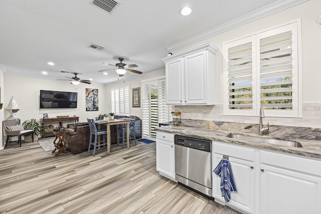 kitchen with stone countertops, sink, white cabinets, and stainless steel dishwasher