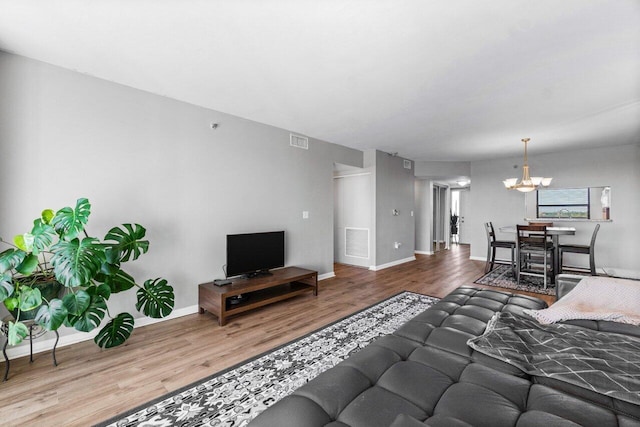 living room with wood-type flooring and a notable chandelier