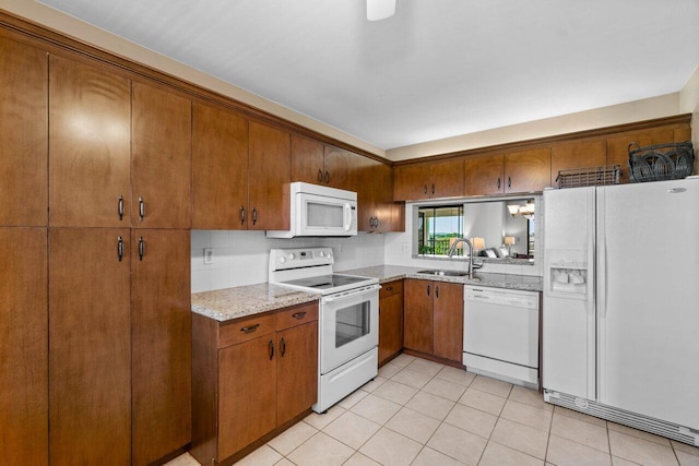 kitchen with sink, tasteful backsplash, light stone counters, white appliances, and light tile patterned floors