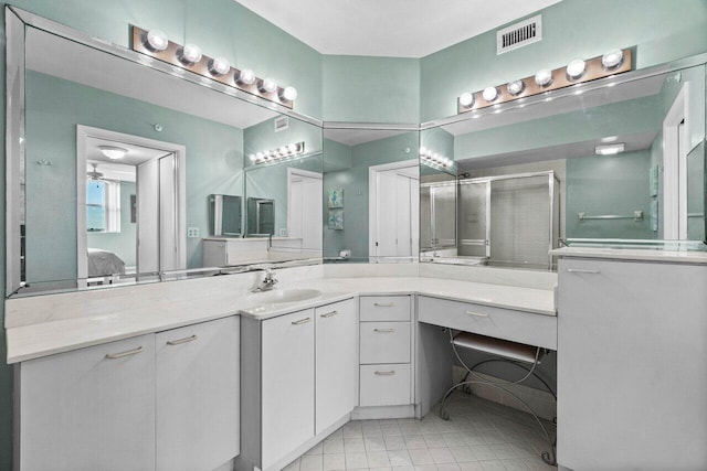 bathroom with tile patterned flooring, vanity, and an enclosed shower