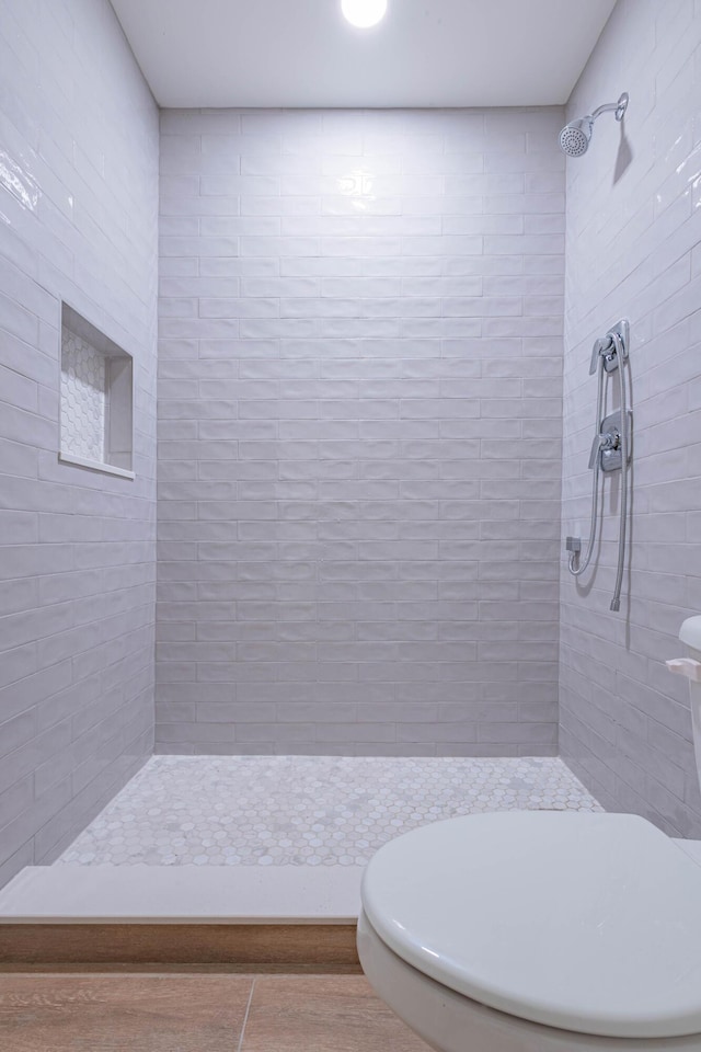 bathroom with tile patterned flooring and tiled shower