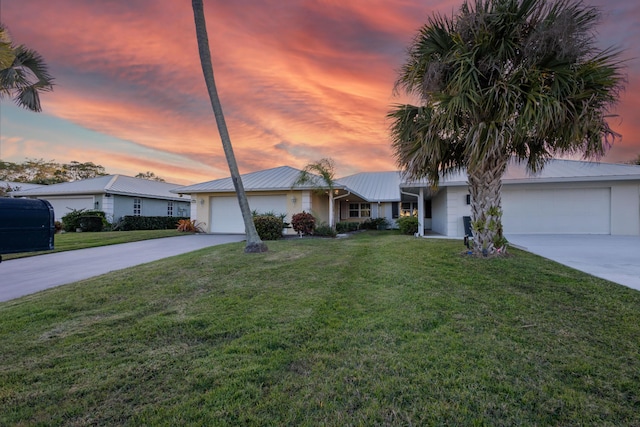 single story home featuring a garage and a yard