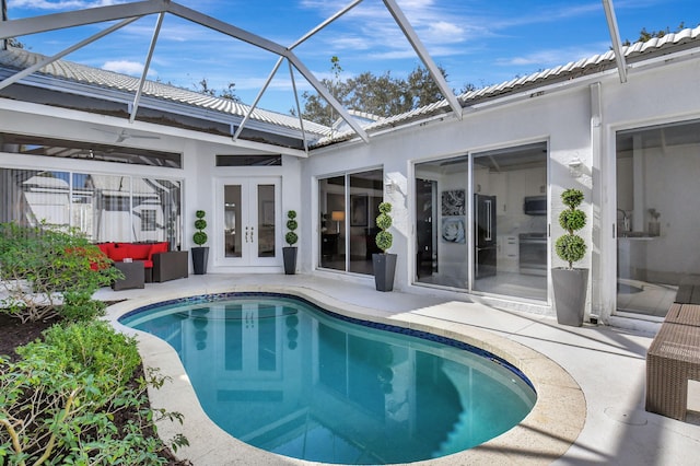 view of pool with outdoor lounge area, a patio area, a lanai, and french doors