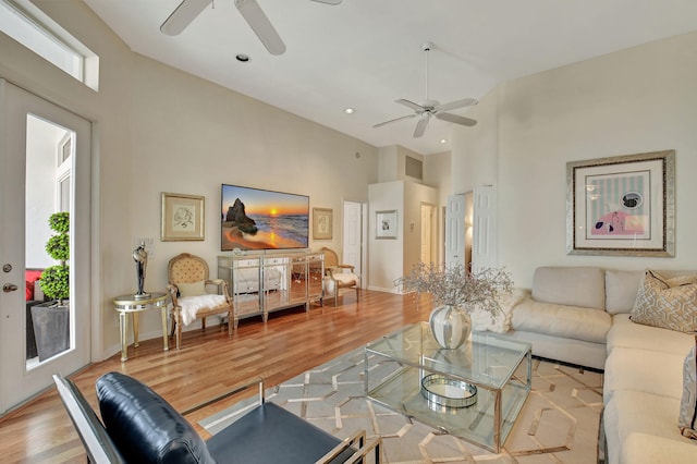 living room featuring light wood-type flooring and a towering ceiling