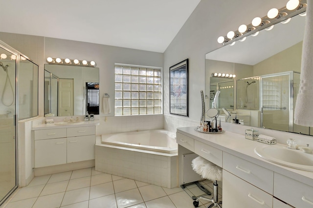 bathroom featuring tile patterned flooring, vanity, vaulted ceiling, and plus walk in shower