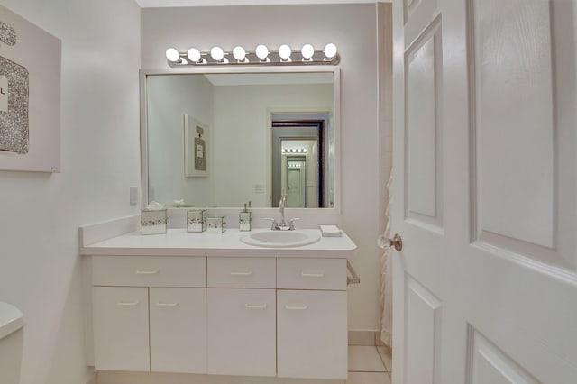 bathroom with toilet, vanity, and tile patterned floors