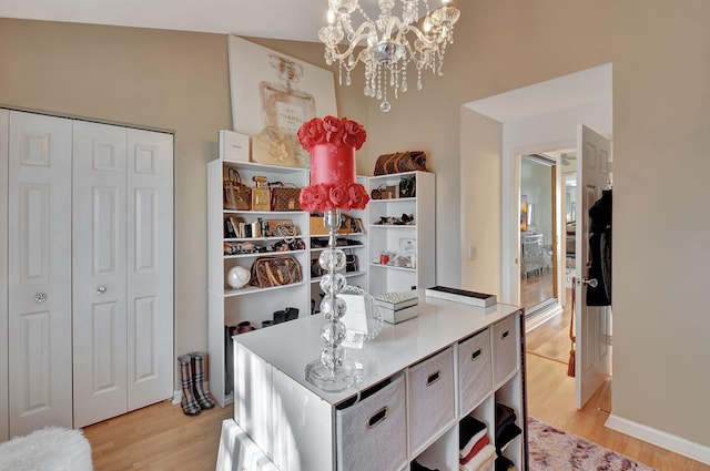 kitchen featuring a chandelier, decorative light fixtures, light hardwood / wood-style floors, and vaulted ceiling