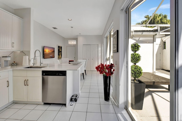 kitchen with white cabinetry, sink, an inviting chandelier, stainless steel dishwasher, and kitchen peninsula