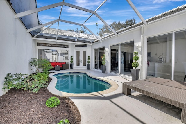 view of pool with glass enclosure, a patio, and an outdoor hangout area