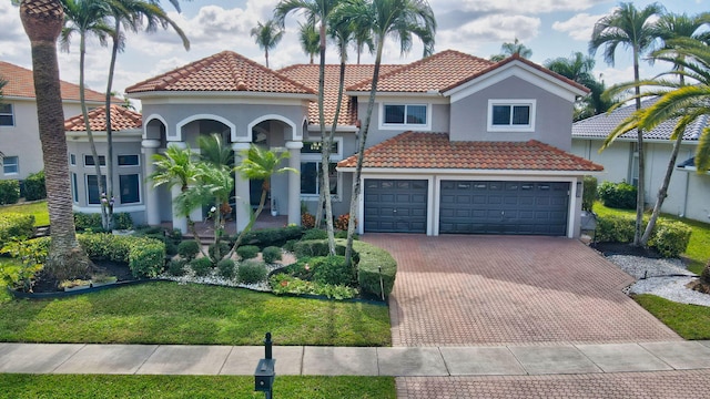 mediterranean / spanish-style home with a front yard and a garage