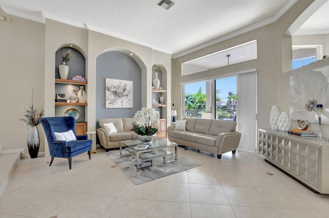 living room with built in shelves, a textured ceiling, ornamental molding, and light tile patterned floors