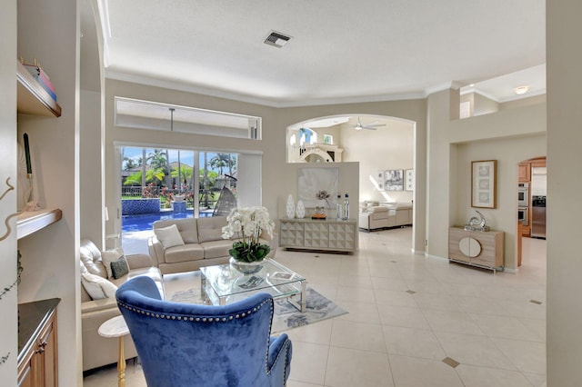 tiled living room featuring ceiling fan and crown molding