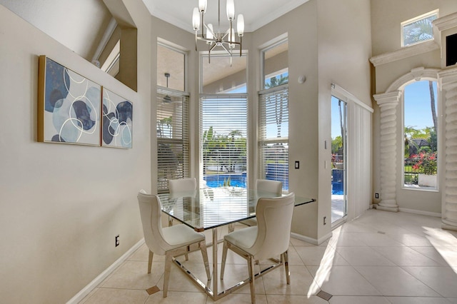 dining area with ornamental molding, a notable chandelier, light tile patterned floors, and ornate columns