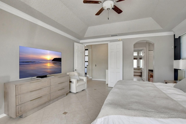 bedroom featuring a raised ceiling, ceiling fan, light tile patterned floors, and a textured ceiling