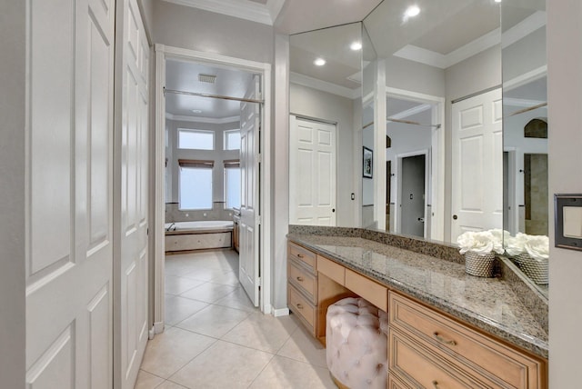 bathroom featuring tile patterned flooring, crown molding, vanity, and a bathing tub