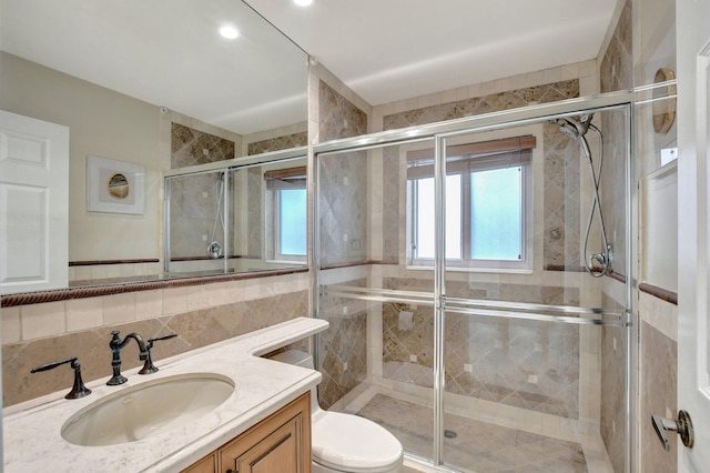 bathroom with toilet, a shower with door, and vanity