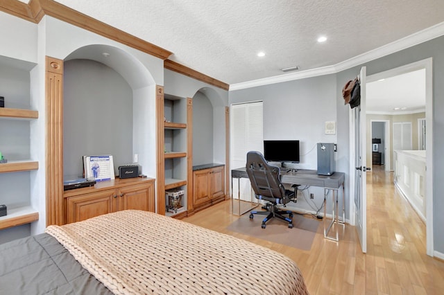 bedroom with a textured ceiling, crown molding, and light hardwood / wood-style flooring