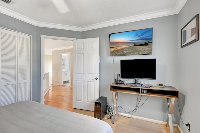 bedroom featuring light wood-type flooring, ceiling fan, crown molding, and a closet