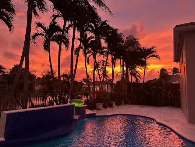 pool at dusk featuring a patio