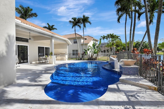 view of pool with exterior kitchen, a patio area, and ceiling fan