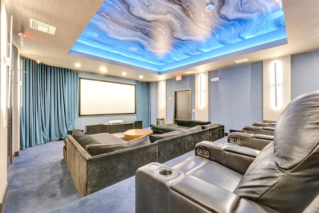 home theater featuring a raised ceiling and carpet