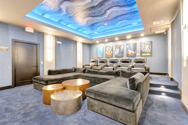 carpeted cinema room with a tray ceiling