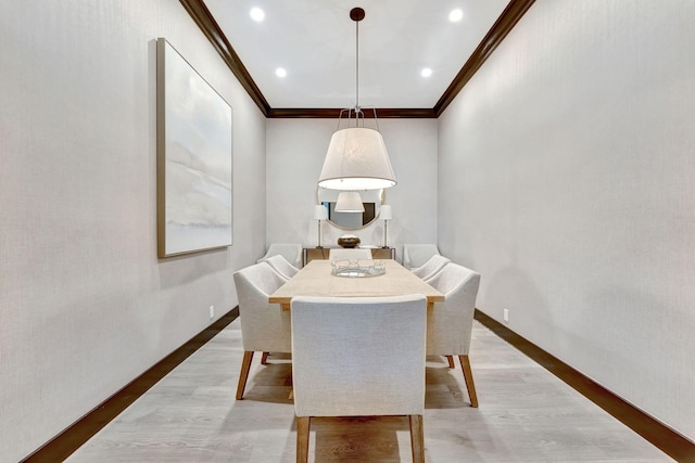 dining room with ornamental molding and light hardwood / wood-style floors