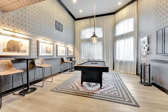 playroom featuring pool table, indoor bar, ornamental molding, and light hardwood / wood-style floors