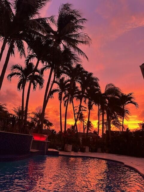 pool at dusk featuring a patio area