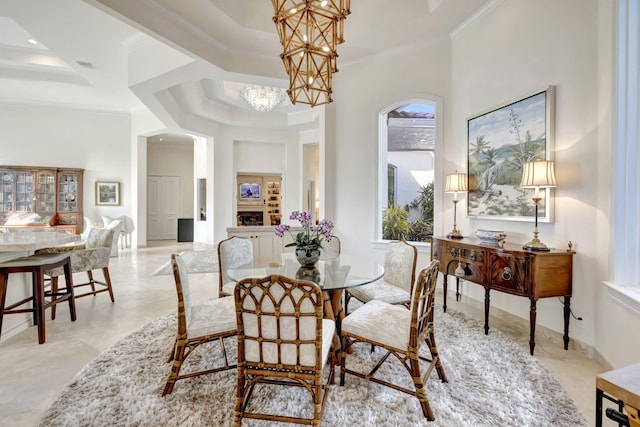 dining space featuring ornamental molding, an inviting chandelier, and a tray ceiling