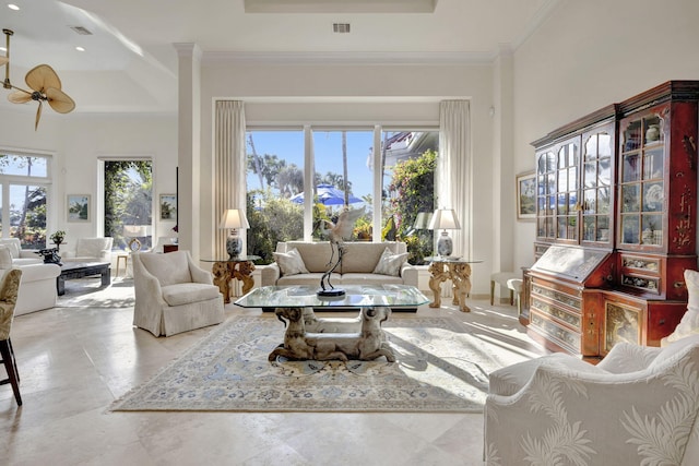 living room featuring ornamental molding, ceiling fan, a tray ceiling, and plenty of natural light