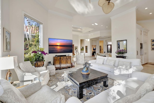 living room featuring ceiling fan, crown molding, and a tray ceiling