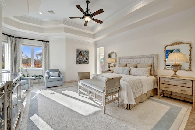 bedroom with ornamental molding, ceiling fan, and a tray ceiling