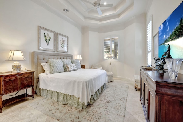 bedroom with ceiling fan, a tray ceiling, and ornamental molding